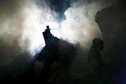 La silueta de un hombre, entre el humo de un incendio de un barrio de Daca (Bangladés).