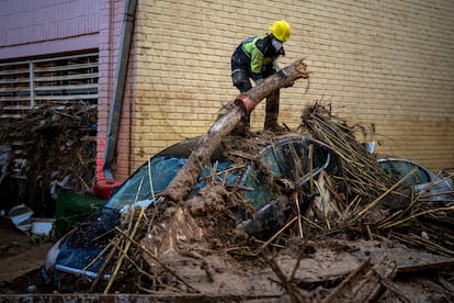 Un bombero retira un tronco de un vehículo en Massanassa, este miércoles. 