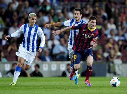 Estrada agarra a Messi ante la mirada de Griezmann.