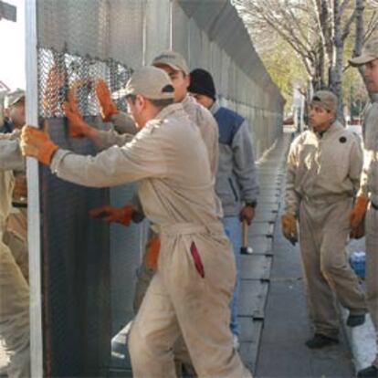 Empleados de seguridad terminan de instalar bardas de acero en el lugar de la cumbre.