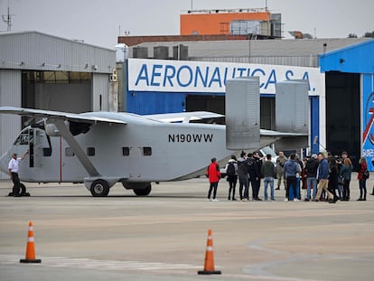 Members of human rights organizations, relatives and victims of the dictatorship, gather behind the Short SC-7 Skyvan aircraft used in the last Argentine military dictatorship (1976-1983) as it sits on the tarmac upon landing at Jorge Newbery International Airport in Buenos Aires, on June 24, 2023.