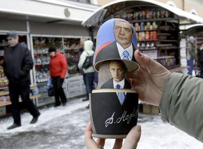 Un vendedor muestra una tradicional <i>matrioshka</i> rusa con los retratos de Dmitri Medvédev y Vladímir Putin en San Petersburgo.