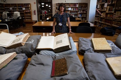 Isabel Ruiz de Elvira, directora del departamento de Manuscritos, Incunables y Raros de la Biblioteca Nacional, junto a varios ejemplares que ha devuelto la abadía del Valle de los Caídos.