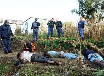 Policías surafricanos, ante tres víctimas de los ataques xenófobos en las afueras de Johanesburgo.
