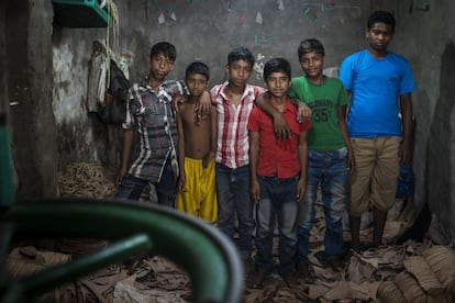 Rakib Mridha (a la izquierda) posa con sus compañeros de trabajo en la fábrica de suelas de zapatos. "Me gusta estudiar inglés para poder entender a los extranjeros", asegura. Él y Rahat (tercero por la derecha) cursan quinto de primaria en la escuela de Educo en el 'slum' de Hazaribag.