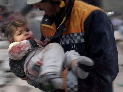 Un rescatista llevaba en brazos a un niño rescatado desde los escombros de un edificio en Azaz (Siria), el lunes.