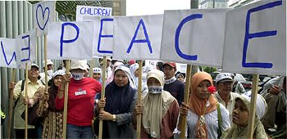 Varias mujeres forman con sus carteles la palabra "paz" en una manifestación contra la guerra realizada en Indonesia.