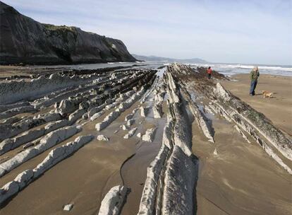 Formaciones rocosas con estratos verticales, conocidas como <i>flysch,</i> un milhojas de piedra en la playa de Itzurun, en Zumaia (Guipúzcoa).