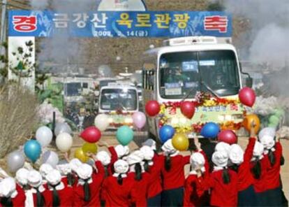 Estudiantes norcoreanos dan la bienvenida a los autobuses con 400 turistas que han cruzado desde el sur.