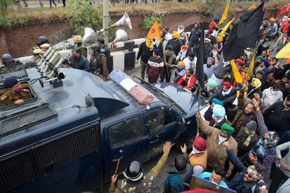 Agricultores detienen un vehículo policial durante una marcha a la capital de la India, Nueva Delhi, para protestar contra las recientes reformas agrícolas del Gobierno central.