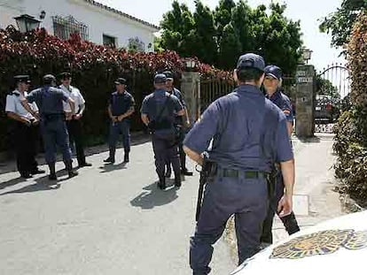 Agentes de policía custodian la casa de Julián Muñoz durante el registro policial.