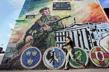 Una mujer pasa delante de un mural a favor del IRA ayer en el oeste de Belfast.