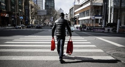 Un hombre cruza una calle en Shanghái (China).