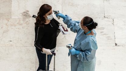 A traveler has her temperature taken at Madrid-Barajas airport.