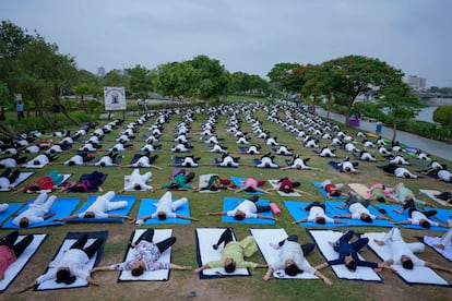 Oficiales militares de distinto rango participan
en sesiones conjuntas de yoga en zonas fronterizas, ríos, e incluso en la helada cordillera del Himalaya. En la imagen, miembros de las Fuerzas de Acción Rápida de India, junto a sus familiares, practican yoga en la víspera del Día Internacional del Yoga en la ciudad india de Ahmedabad.