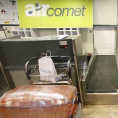 Pasajeros de Air Comet en un mostrador de facturación