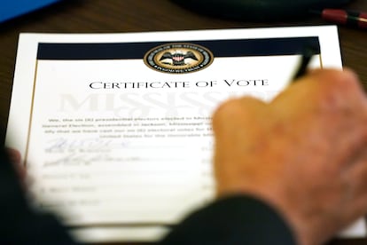 Un miembro del Colegio Electoral de Mississippi firma el acta tras depositar su voto.