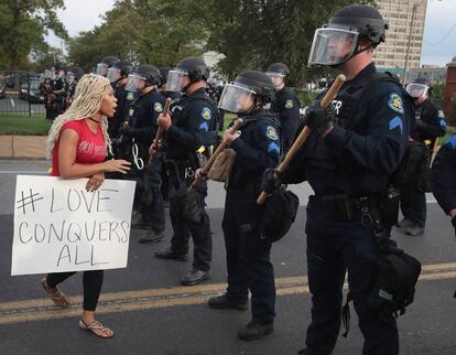 Los manifestantes han continuado las protestas durante tres días consecutivos. En la foto, una mujer se enfrenta a los agentes con una pancarta que lee 'Love conquers all' (El amor conquista todo) el 17 de septiembre de 2017 en San Luis.