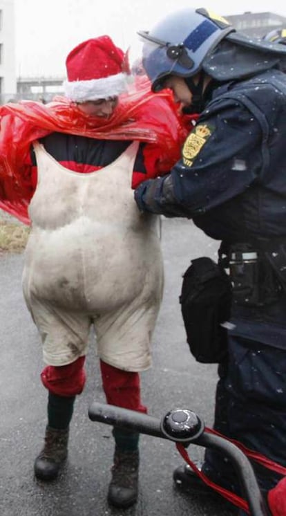 Un policía cachea a un activista en la cumbre del clima.