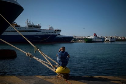 Un hombre se sienta en un bitt de amarre frente a los transbordadores atracados en el puerto de El Pireo, en Atenas (Grecia) durante una segunda huelga consecutiva de 24 horas de las tripulaciones de los transbordadores.