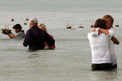 Dos ciudadanas suecas Sse abrazan en el agua después de lanzar al agua un kratong, una vela ceremonial, para recordar a varios de sus compatriotas fallecidos en la catástrofe, mientras hacían turismo a 100 kilómetros del emblemático "resort" de Phuket.