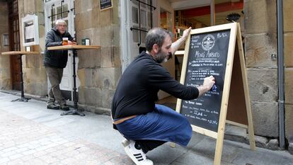 Un empleado del restaurante Anboto del Casco Viejo de Bilbao anota el menú del día en la pizarra del establecimiento.