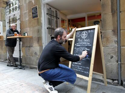 Un empleado del restaurante Anboto del Casco Viejo de Bilbao anota el menú del día en la pizarra del establecimiento.