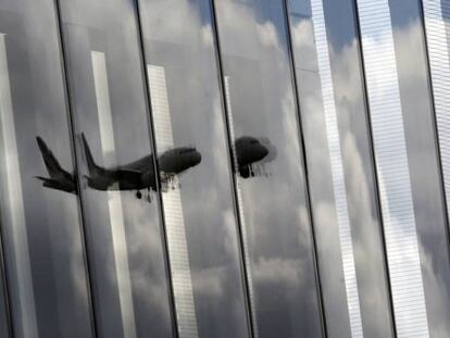 Un avi&oacute;n de Air France se refleja en un cristal de un complejo de oficinas en Ginebra.