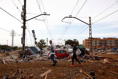 Residentes caminan entre las vías del tren en Alfafar (Valencia), este viernes. 