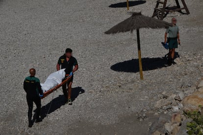 Los agentes de la Guardia Civil trasladan al fallecido, este miércoles, en una de las playas más lejanas a la frontera. 