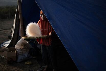Una mujer avienta arroz en un refugio temporal.