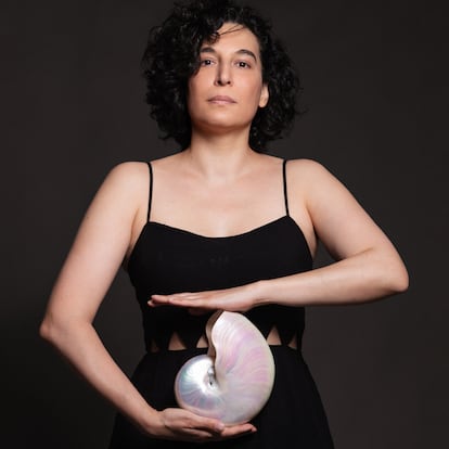 Retrato promocional de la autora Olalla Castro, que sostiene una concha narina como metáfora de la escucha.