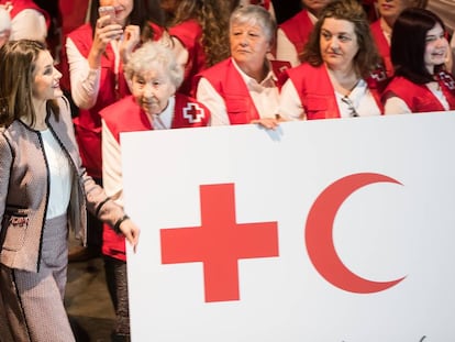 La reina Letizia saluda a su llegada a los voluntarios de la Cruz Roja presentes en el acto del Palacio de Congresos de Santiago.