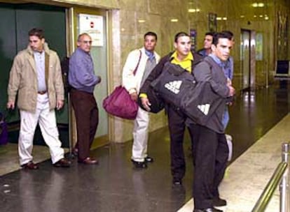 Varios de los cubanos llegados a Madrid abandonan la sala de retenidos de Barajas.