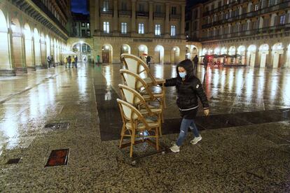 Una operaria recoge unas sillas este lunes en la Plaza Constitución de San Sebastián.