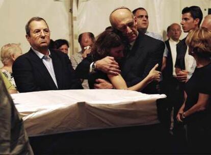 El primer ministro israelí, Ehud Olmert, abraza a la viuda del soldado Ehud Goldwasser junto a su féretro, en la base militar de Shraga.