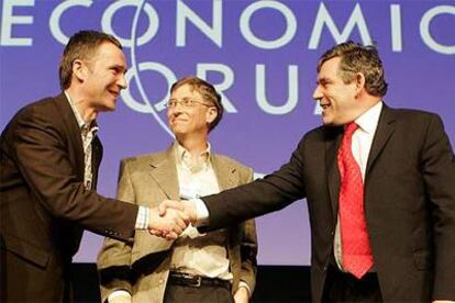 Bill Gates observa el saludo del primer ministro noruego, Jens Stoltenberg (izquierda), y el ministro británico de Hacienda, Gordon Brown, ayer en Davos.
