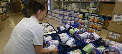 Una mujer retira botes de leche en un establecimiento en Francia.