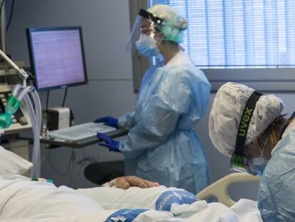Personal sanitario atiende a un paciente ingresado en una Unidad de Cuidados Intensivos para enfermos de coronavirus.