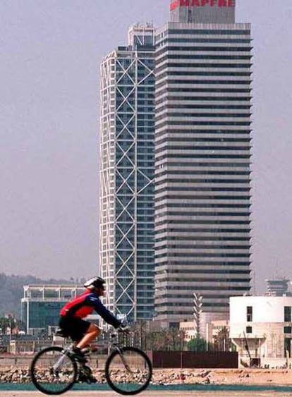 Un ciclista pasea ante la torre Mapfre en la Villa Olímpica Barcelona.