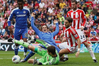 Fernando Torres cae ante la entrada del portero del Stoke City.