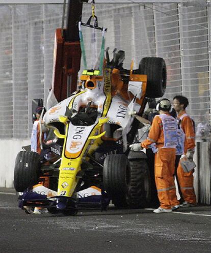 Los operarios del circuito de Singapur retiran el coche de Piquet en 2008.
