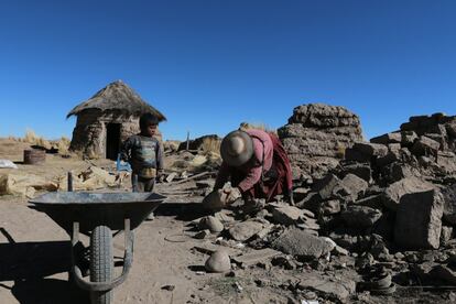 Natividad y su nieto recogen los restos de su casa derrumbada por falta de mantenimiento. En Llapallapani todavía usan el método tradicional para hacer sus casas de adobe. 