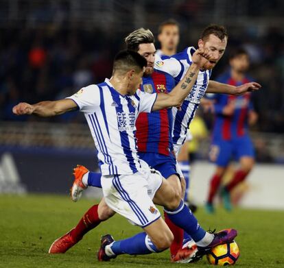 El delantero argentino del FC Barcelona, Leo Messi (c), intenta llevarse el balón ante los jugadores de la Real Sociedad, Yuri Bernache (i) y David Zurutuza.