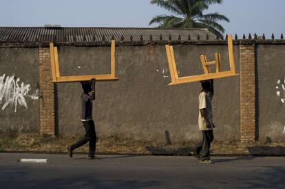 Unos hombres llevan unos muebles sobre la cabeza por las calles de Bujumbura, Burundi.