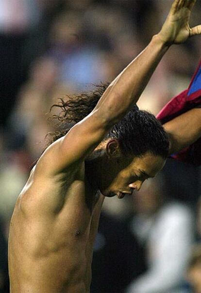 Ronaldinho, después de quitarse la camiseta, levanta los brazos celebrando su gol.