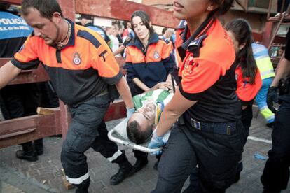 Personal sanitario traslada en camilla a un herido en el cuarto encierro de las fiestas patronales.