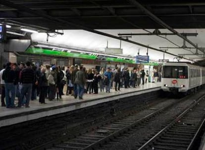 Los viajeros aguardan en el andén de la estación de plaza de Catalunya la llegada del tren. Unos 25.000 usuarios utilizaron el suburbano en Barcelona aquella primera noche, aunque no se registraron grandes aglomeraciones porque el acceso a este transporte fue gradual durante toda la velada.