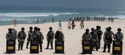 Police form a blockade on Monday during the bid-awarding ceremony at a nearby hotel on Barra de Tijuca beach in Rio de Janeiro.