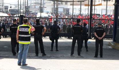 Policías españoles vigilan a activistas con banderas marroquíes en la frontera de Melilla.